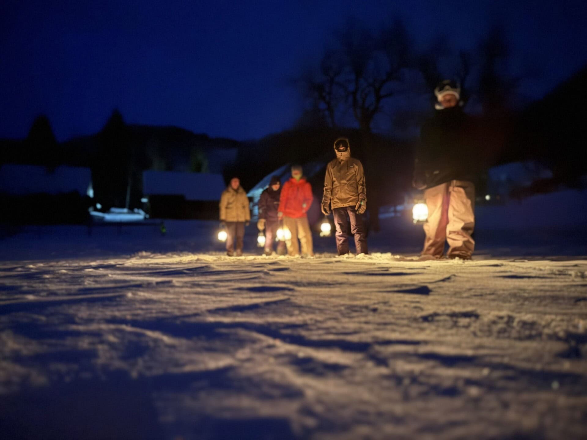Night lantern snowshoe lantern walk in Bohinj, Slovenia illuminated by lanterns highlighting winter landscape and outdoor adventure.