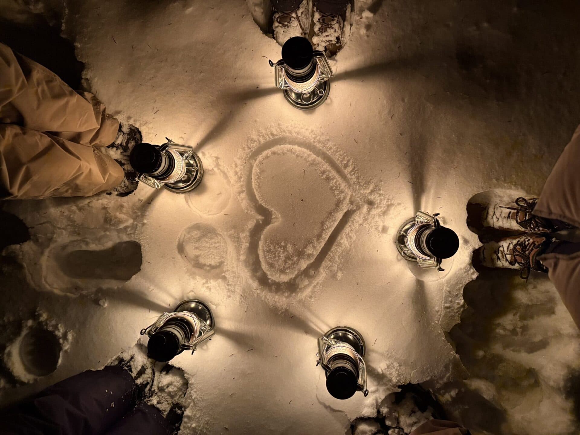 Night snow hike in Slovenia illuminated by lanterns, winter outdoor activity in the mountains.